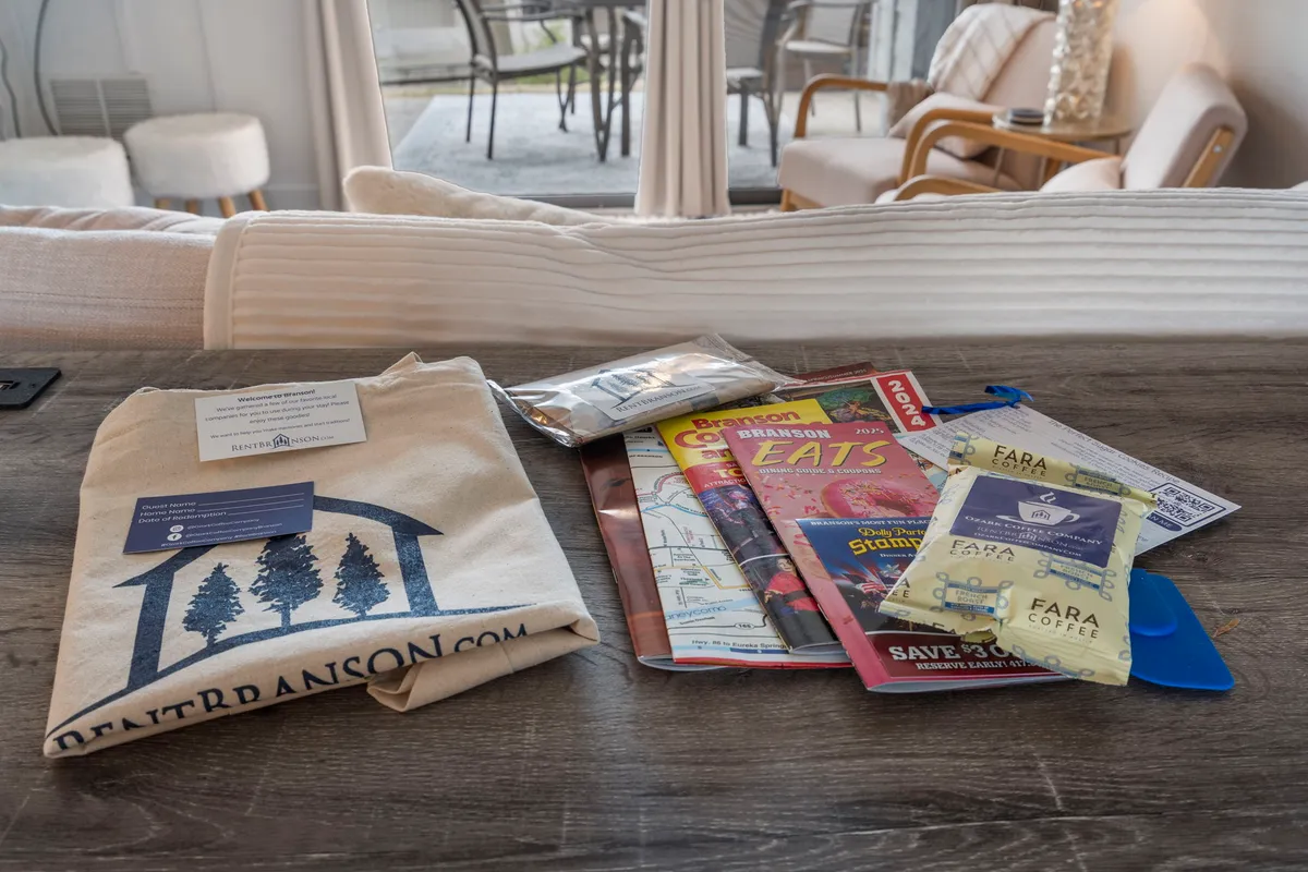 A cozy scene features a branded tote bag, brochures for local attractions, and coffee packets arranged invitingly on a table. The layout encourages guests to explore local activities while enjoying a relaxing start to their day.
