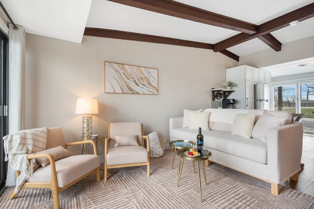 A cozy corner of the living room featuring a plush sofa, comfortable armchairs, a coffee table, tasteful artwork, and a softly glowing lamp. The scene is set for relaxation, intimate conversations, or unwinding after a day of adventure.